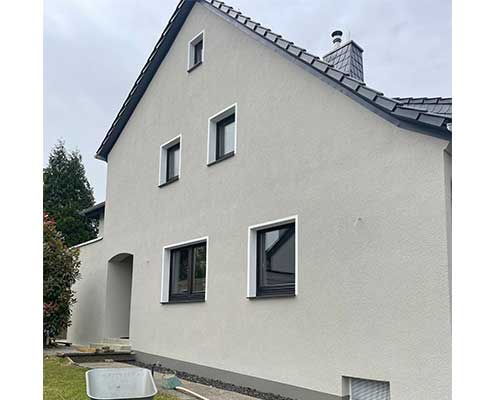 Fassadensanierung Einfamilienhaus – Hellgrauer Putz & weiße Laibungen | Malerfachbetrieb Binde