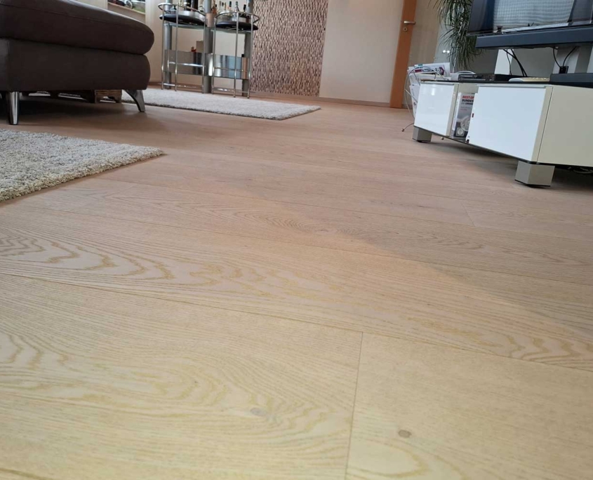 Helles Holzlaminat im Wohnzimmer – Malerfachbetrieb Binder Wohnzimmer mit frisch verlegtem hellem Holzlaminat – Bodenarbeiten vom Malerfachbetrieb Binder